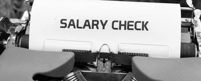 The words salary check written on a piece of paper in a typewriter