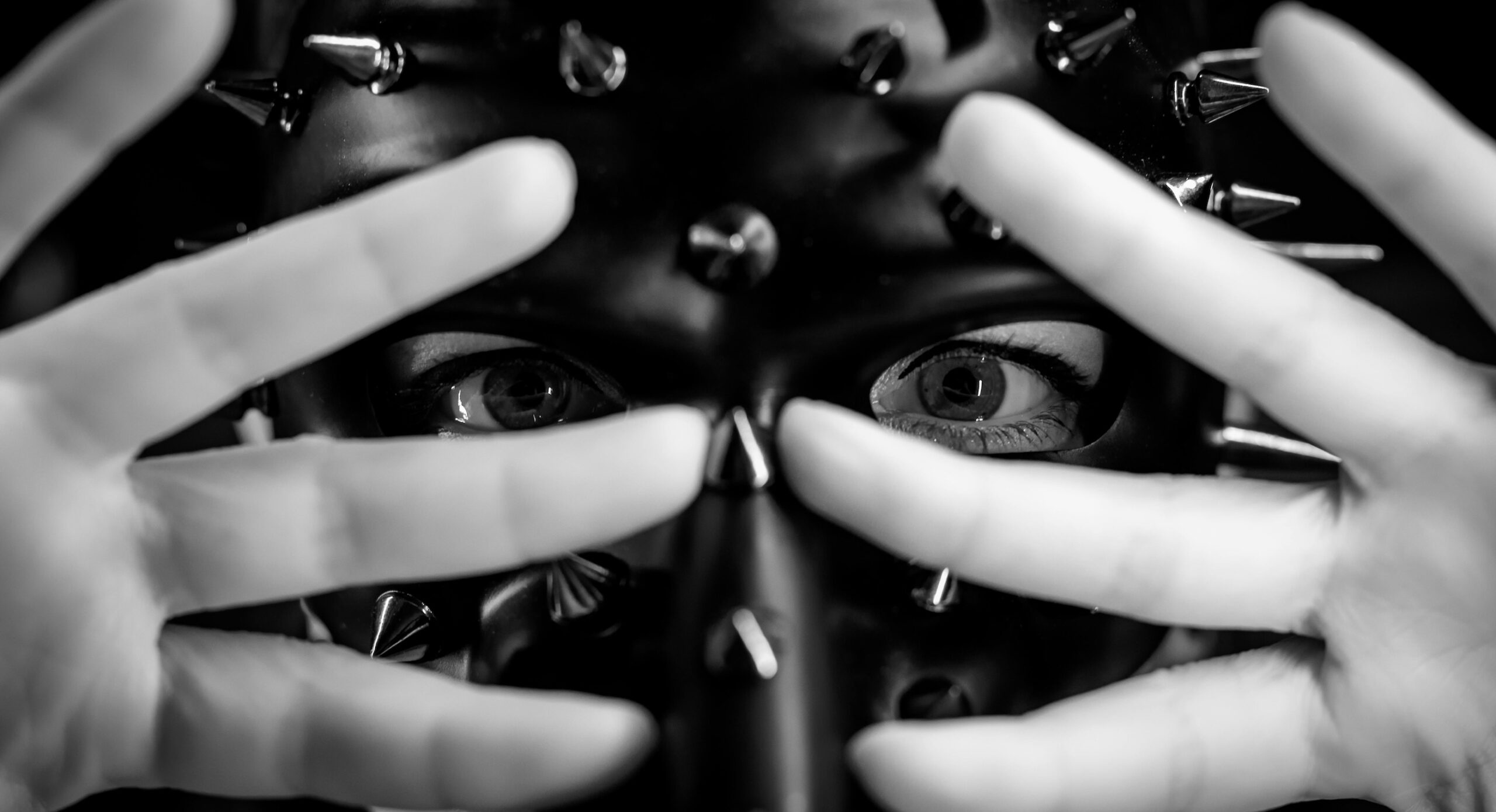 Closeup of person in a mask with their fingers over their face