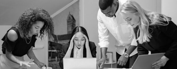 Stressed team huddled around a desk